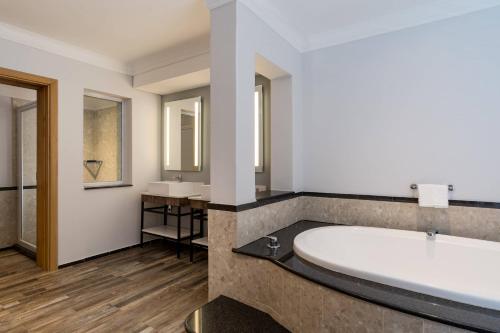 baño con bañera grande y 2 lavabos en Protea Hotel by Marriott Johannesburg Wanderers en Johannesburgo