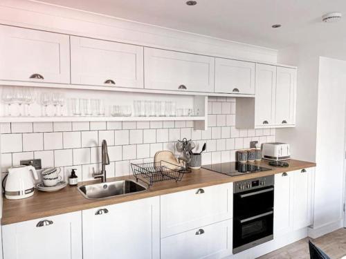 a kitchen with white cabinets and a sink at The Estuary in Dundee