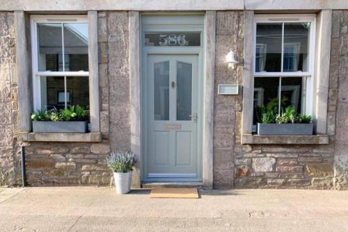a house with a blue door and two windows at The Estuary in Dundee