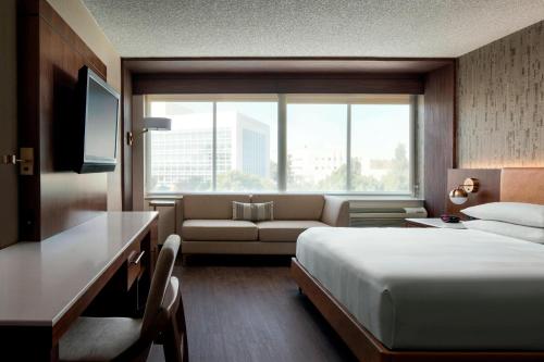 a hotel room with a bed and a couch at Fullerton Marriott at California State University in Fullerton