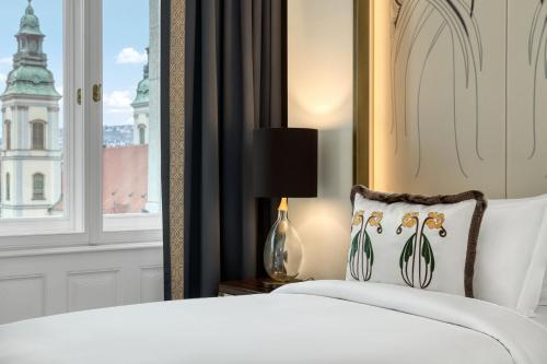 a bedroom with a white bed and a window at Matild Palace, a Luxury Collection Hotel in Budapest