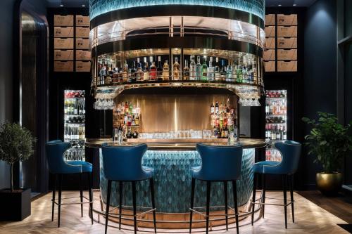 a nightclub with a bar with blue bar stools at Matild Palace, a Luxury Collection Hotel in Budapest