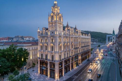 un grande edificio con una torre dell'orologio sopra di Matild Palace, a Luxury Collection Hotel a Budapest