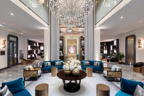 a lobby with blue couches and a chandelier at Matild Palace, a Luxury Collection Hotel in Budapest