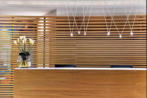 a wooden wall with a vase of flowers on a counter at Le Méridien Beach Plaza in Monte Carlo