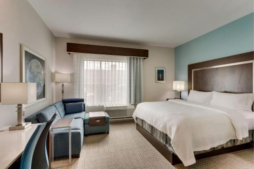 um quarto de hotel com uma cama grande e um sofá em TownePlace Suites Houston I-10 East em Houston