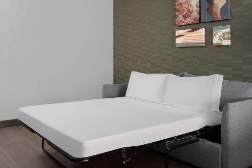a white bed in a room with a couch at Element Moab in Moab