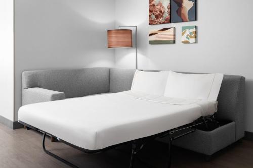 a white bed in a room with a couch at Element Moab in Moab