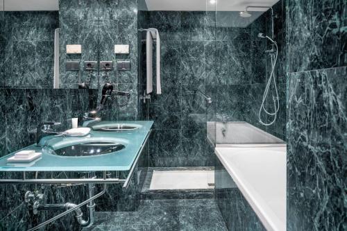 a black bathroom with a sink and a bath tub at AC Hotel La Rioja by Marriott in Logroño