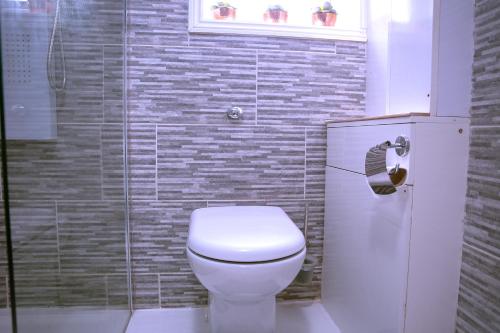 a bathroom with a white toilet and a shower at Rostron House in Manchester