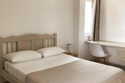 Curepipe的住宿－La Péninsule - Town Apartment No. 3，卧室配有白色的床和窗户。