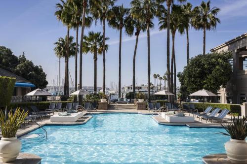 a swimming pool with chairs and palm trees at The Ritz-Carlton, Marina del Rey in Los Angeles