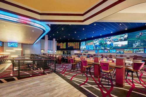 a restaurant with red chairs and tables and televisions at JW Marriott Las Vegas Resort & Spa in Las Vegas