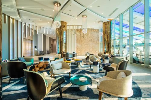 a lobby with chairs and tables and windows at Paragraph Resort & Spa Shekvetili, Autograph Collection in Shekvetili