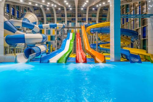 a large indoor water park with a water slide at Paragraph Resort & Spa Shekvetili, Autograph Collection in Shekvetili