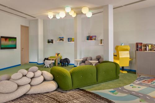 a living room with a green couch and a table at Paragraph Resort & Spa Shekvetili, Autograph Collection in Shekvetili