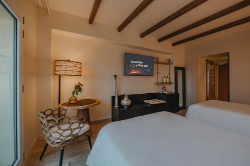 a bedroom with a bed and a table and a tv at Renaissance Wind Creek Aruba Resort in Oranjestad