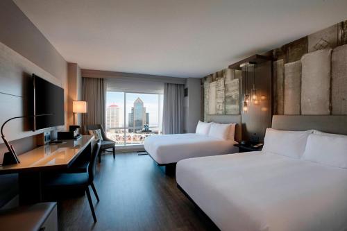 ルイスビルにあるLouisville Marriott Downtownのベッド2台とデスクが備わるホテルルームです。
