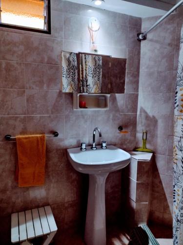 La salle de bains est pourvue d'un lavabo blanc et d'une douche. dans l'établissement Depto. El duende, à Olavarría