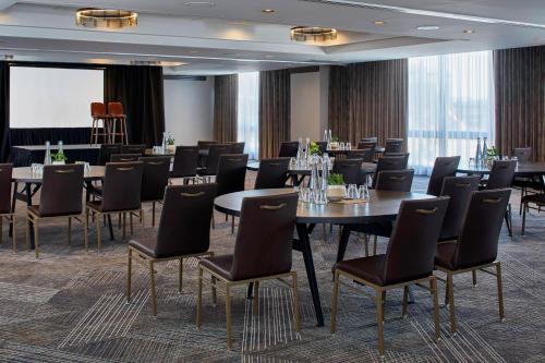 a conference room with tables and chairs and a screen at Renaissance Nashville Hotel in Nashville