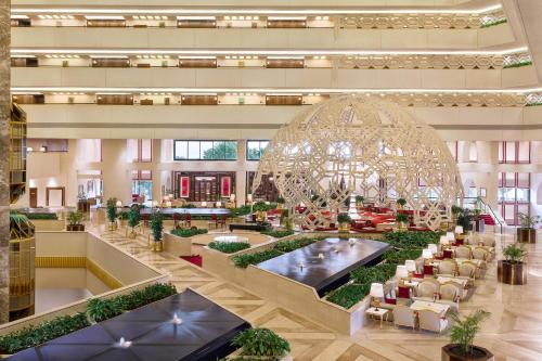 a large lobby with a large chandelier in a building at Sheraton Grand Doha Resort & Convention Hotel in Doha