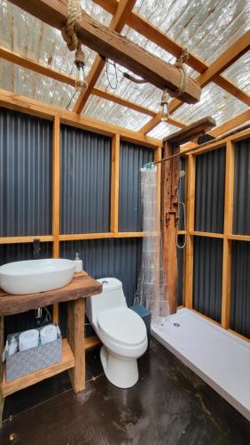 a bathroom with a toilet and a sink and a tub at Glamping Matanzas Lodge & Glamp in Matanzas