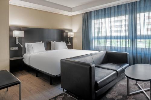 ビトリア・ガステイスにあるB&B HOTEL Vitoria General Álavaのベッドとソファ付きのホテルルーム