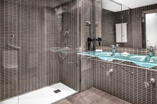 W łazience znajduje się szklana kabina prysznicowa i umywalka. w obiekcie B&B HOTEL Vitoria General Álava w mieście Vitoria-Gasteiz