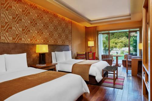 a hotel room with two beds and a window at Tambo del Inka, a Luxury Collection Resort & Spa, Valle Sagrado in Urubamba