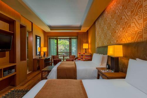 a hotel room with two beds and a television at Tambo del Inka, a Luxury Collection Resort & Spa, Valle Sagrado in Urubamba