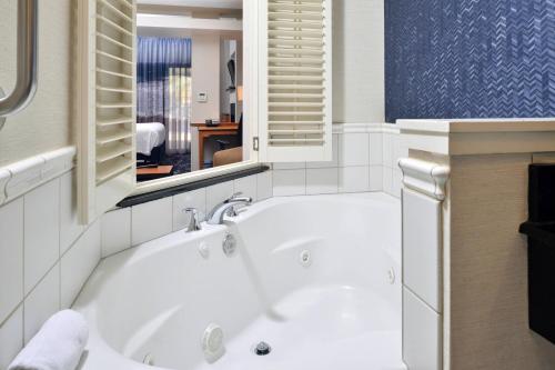 托拉的住宿－桑塔克魯茲費爾菲爾德客棧及套房酒店- 卡皮托拉，带窗户的浴室内的白色浴缸