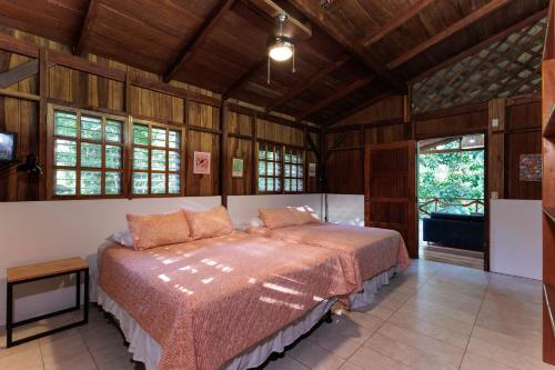 a bedroom with a bed in a room with wooden walls at La Kukula Lodge in Puerto Viejo
