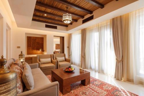 a living room with a couch and a table at Al Wathba, a Luxury Collection Desert Resort & Spa, Abu Dhabi in Abu Dhabi