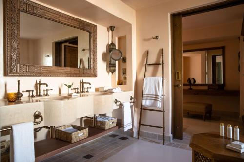 a bathroom with two sinks and a large mirror at Al Wathba, a Luxury Collection Desert Resort & Spa, Abu Dhabi in Abu Dhabi
