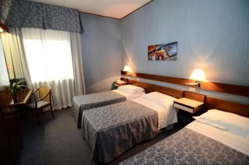 una camera d'albergo con due letti e una finestra di Hotel Al Sant'Andrea a Sarzana