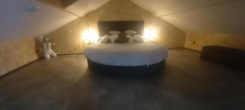 1 dormitorio con 1 cama blanca grande en el ático en L'Esthélio Gîtes ou L'Esthélio Spa avec Jacuzzi et Sauna en Ambérieu-en-Bugey