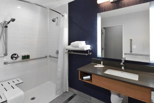 a bathroom with a tub and a sink and a mirror at Fairfield Inn & Suites by Marriott Moorpark Ventura County in Moorpark