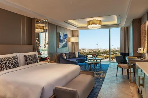 a bedroom with a large bed and a living room at The St. Regis Kuwait in Kuwait