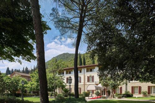 un gran edificio con árboles delante de él en Grotta Giusti Thermal Spa Resort Tuscany, Autograph Collection en Monsummano