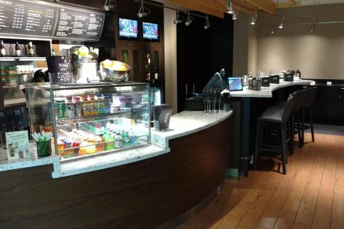 a bar in a restaurant with a counter and tables at Courtyard by Marriott Portland Tigard in Tigard