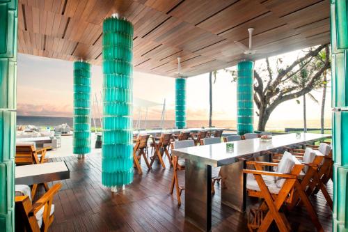 a restaurant with wooden floors and green columns at W Bali - Seminyak in Seminyak
