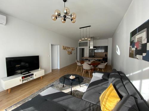 a living room with a couch and a tv at Sundeck City Centre Apartment in Bratislava