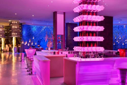a bar with a tall pink cake in a room at W Bali - Seminyak in Seminyak