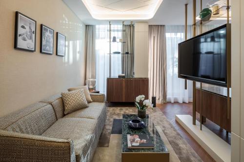 a living room with a couch and a flat screen tv at Casa Baglioni Milan - The Leading Hotels of the World in Milan