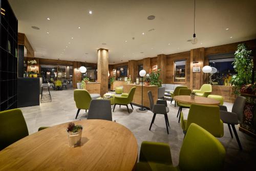 a restaurant with tables and chairs and a lobby at Hotel Bernina in Livigno
