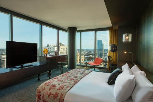 a hotel room with a bed and a desk with a television at W Philadelphia in Philadelphia