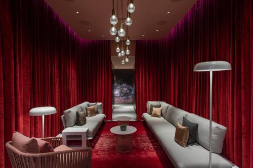 a living room with red curtains and couches at W Philadelphia in Philadelphia