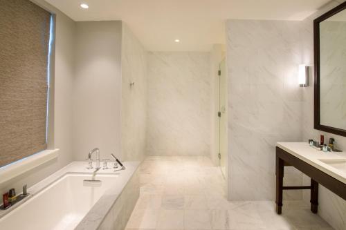 uma casa de banho branca com uma banheira e um lavatório em Marriott Syracuse Downtown em Syracuse