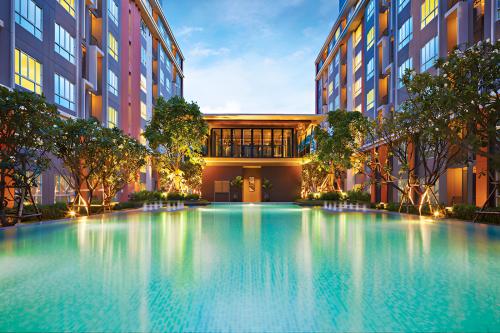 a large swimming pool in front of a building at DCondo Hyde near Central Plaza with Pool and Gym in Ban San Ton Ko (1)
