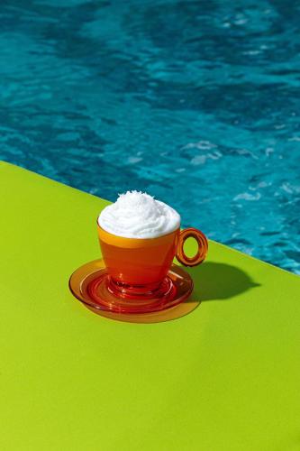 a cup of whipped cream sitting on a table next to a pool at W Philadelphia in Philadelphia